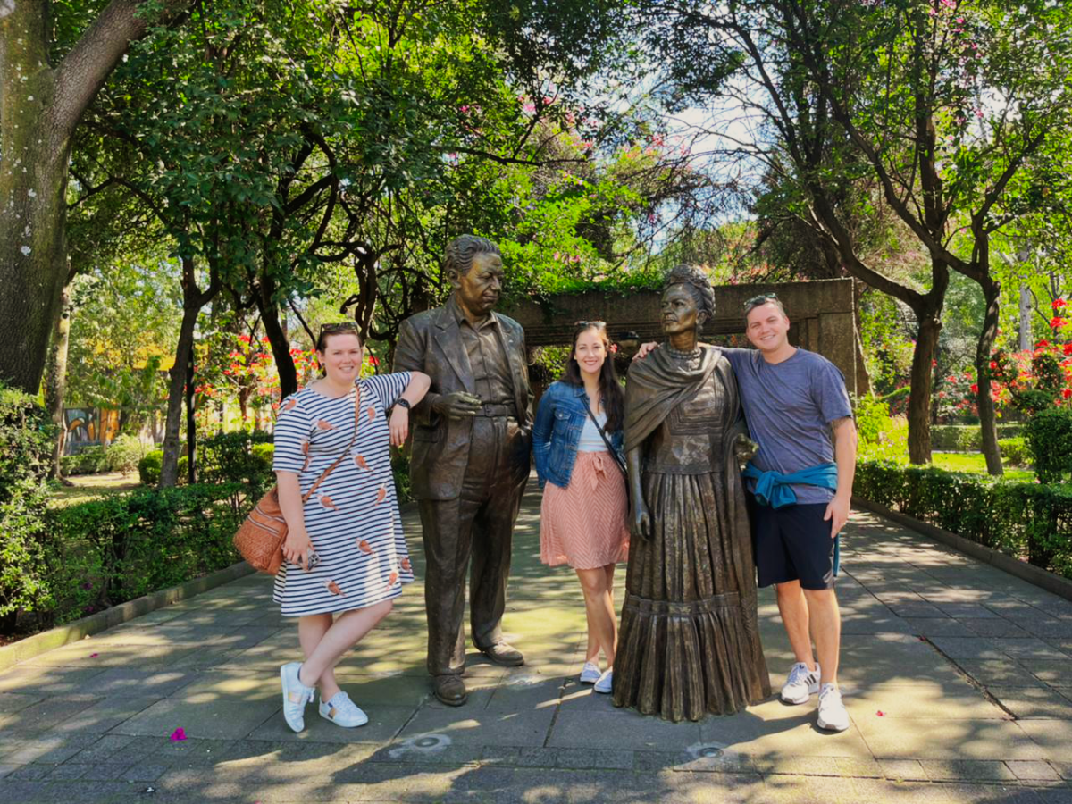 a group of people standing next to a tree