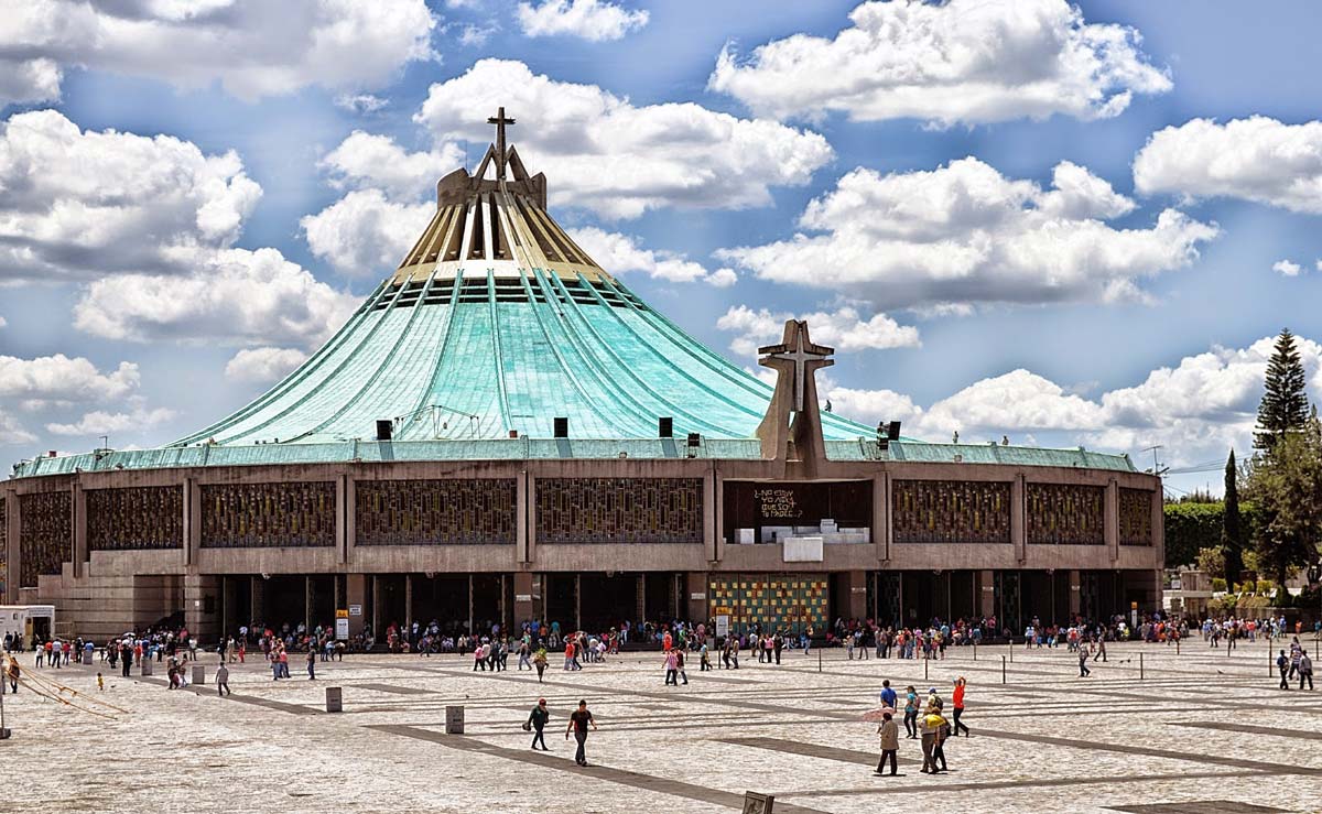 a group of people on a beach in front of Basilica of Our Lady of Guadalupe